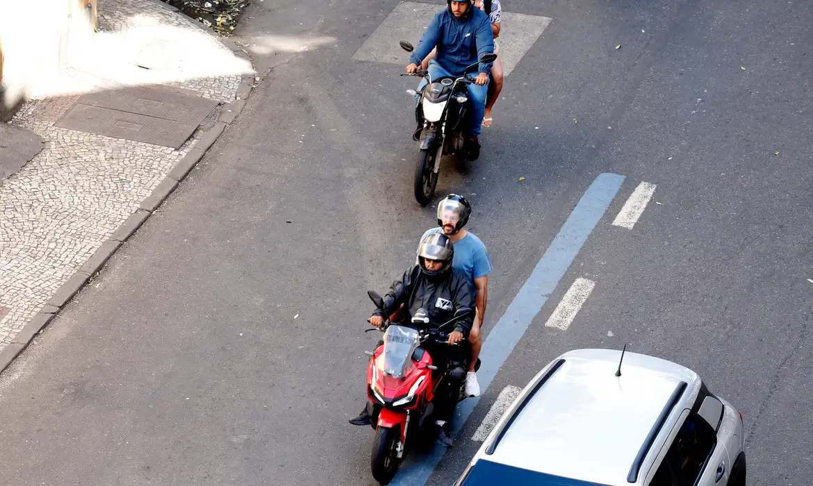 Motociclistas com pessoas nas garupas