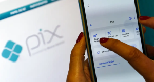 Mão feminina fazendo transação via Pix no celular