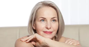 Mulher de cabelo curto e olhos claros, com expressão serena, sem olhar para a câmera