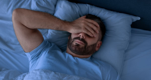 Homem dormindo com a mão no rosto