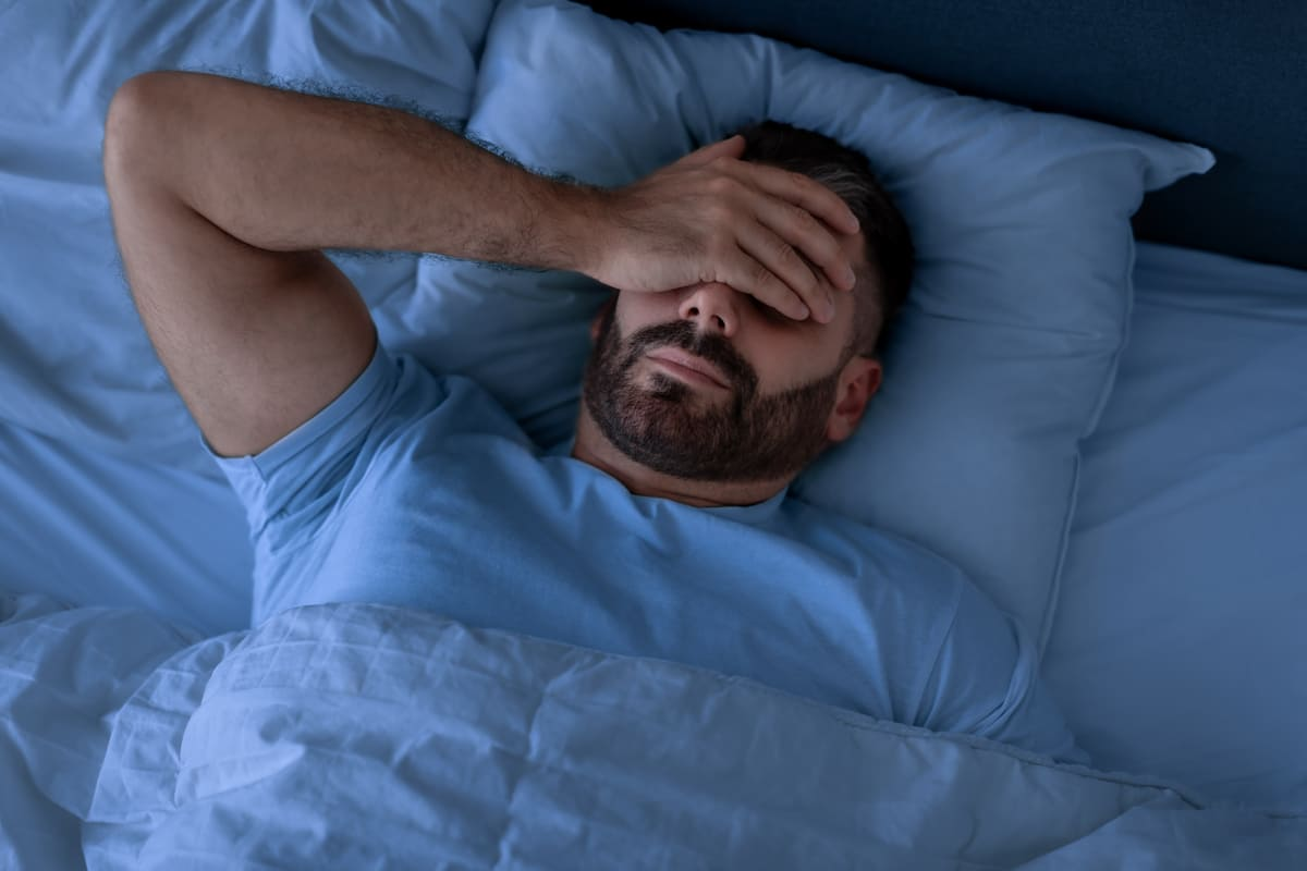 Homem dormindo com a mão no rosto