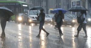 Pessoas com guarda-chuva andando na chuva em São Paulo