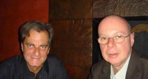 Edgar Moura Brasil e Gilberto Braga olhando para a câmera, lado a lado, o primeiro sorrindo e o segundo sério e de óculos