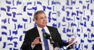 deputado federal Lindbergh Farias (PT) em pé, usando óculos de grau, falando em microfone, sem olhar para a câmera, sério e gesticulando