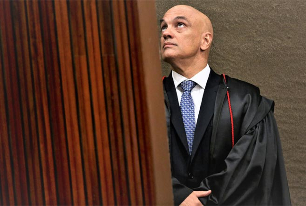 O ministro Alexandre de Moraes, do STF (Supremo Tribunal Federal), olhando pra cima no canto direito de foto, sério
