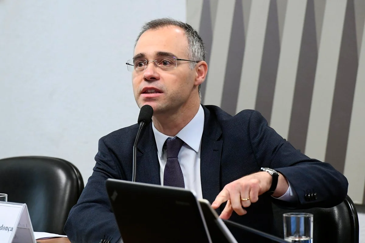 O ministro André Mendonça sentado, falando em microfone sem olhar para a câmera