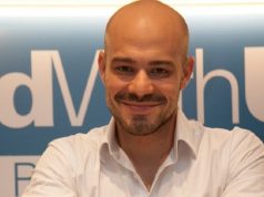 cientista político André Lajst olhando para a câmera com sorriso tímido