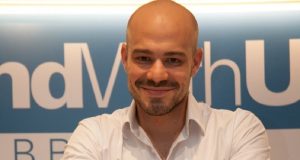 cientista político André Lajst olhando para a câmera com sorriso tímido