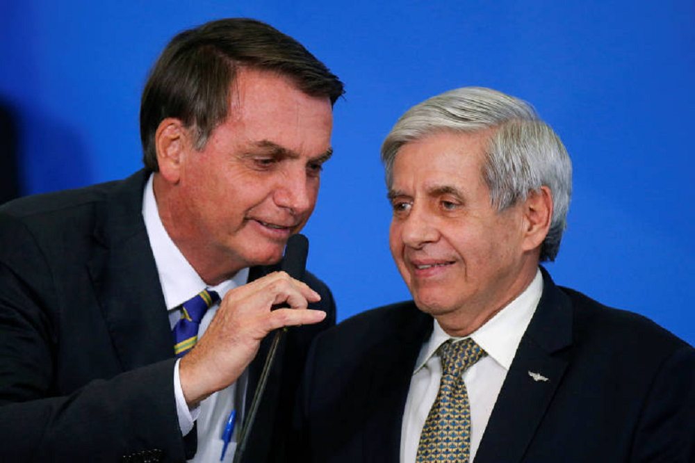 Jair Bolsonaro e Augusto Heleno falando e sorrindo, lado a lado