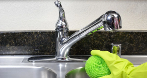 mão com luva esfregando pia