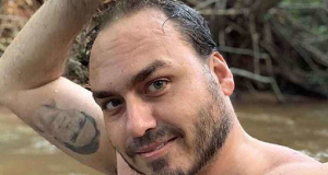 Carlos Bolsonaro sem camisa, molhado, com um dos braços levantados