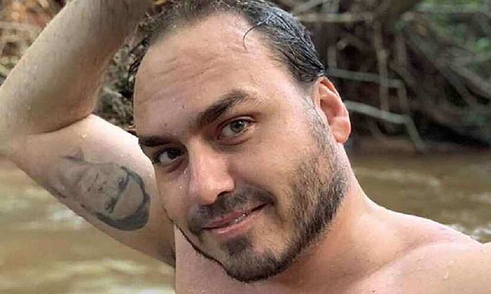 Carlos Bolsonaro sem camisa, molhado, com um dos braços levantados