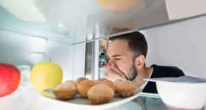 Homem fazendo careta olhando para geladeira