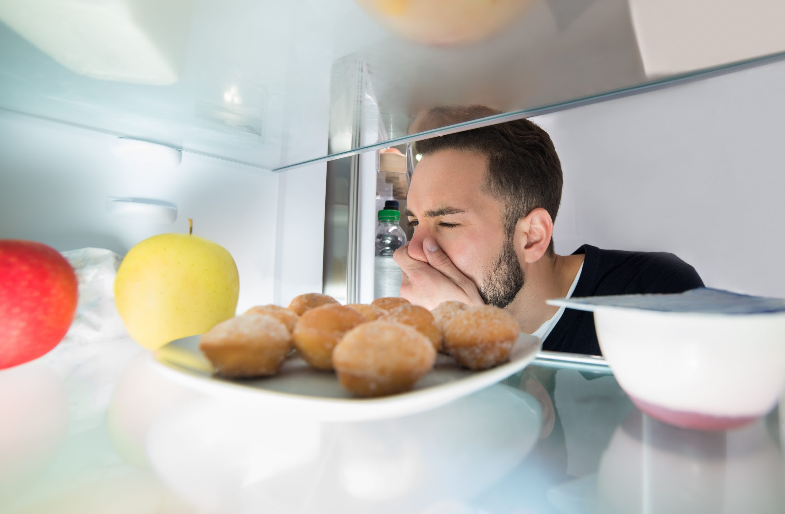 Homem fazendo careta olhando para geladeira
