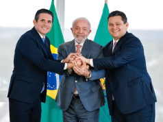 Hugo Motta, Lula e Davi Alcolumbre lado a lado, sorrindo em aperto de mãos