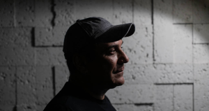 O delegado aposentado Orlando Zaccone, da Policia Civil do RJ, de perfil, de boné, sério, em foto sombreada