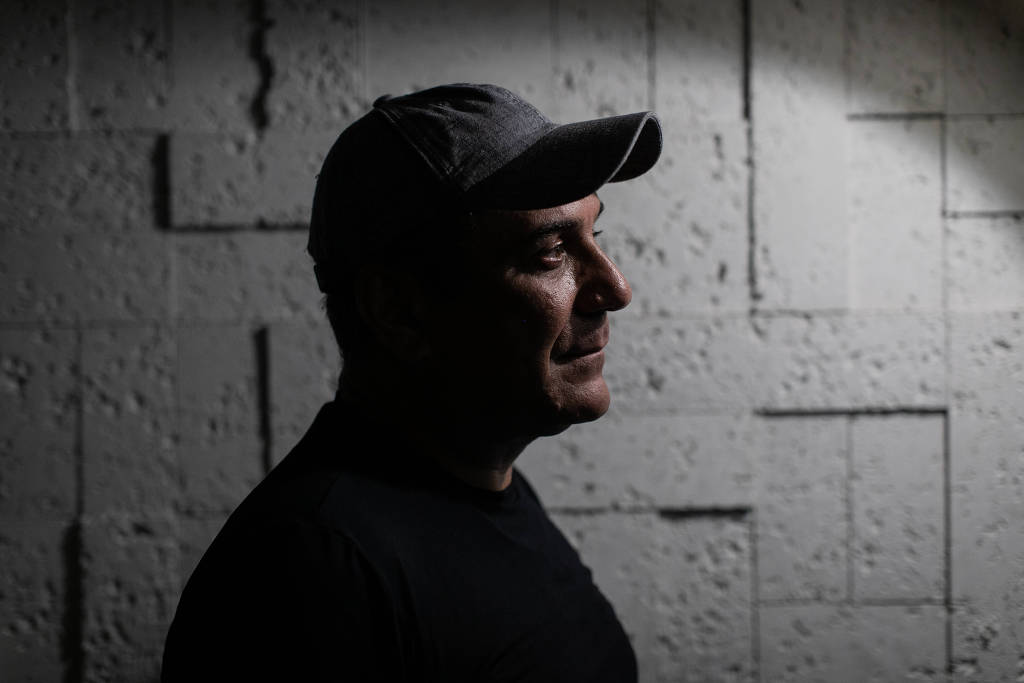 O delegado aposentado Orlando Zaccone, da Policia Civil do RJ, de perfil, de boné, sério, em foto sombreada