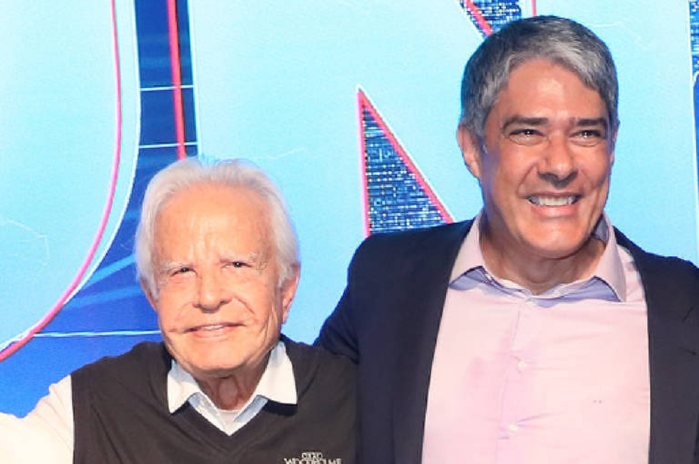 Cid Moreira e William Bonner nos estúdios do JN, se abraçando e sorrindo lado a lado