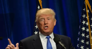 presidente Donald Trump falando e apontando pra cima, sem olhar para a câmera