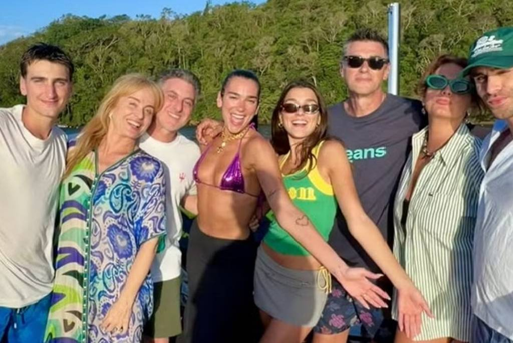 Dua Lipa e família com Luciano Huck e Angélica, todos em pé posando para foto