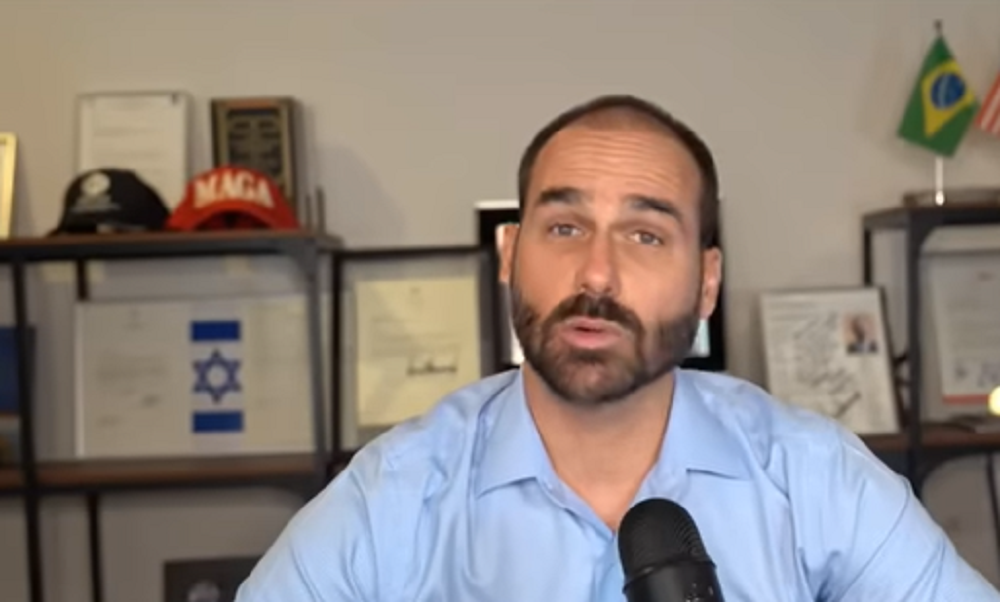 O deputado Eduardo Bolsonaro (PL-SP) de roupa social azul clara, falando para a câmera