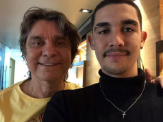 Lô Borges ao lado do filho Luca Arroyo Borges, posando para foto e sorrindo