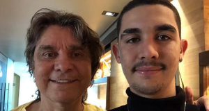 Lô Borges ao lado do filho Luca Arroyo Borges, posando para foto e sorrindo