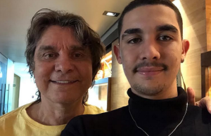 Lô Borges ao lado do filho Luca Arroyo Borges, posando para foto e sorrindo