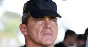 O general Mário Fernandes sério, em close, de boné preto, sem olhar para a câmera