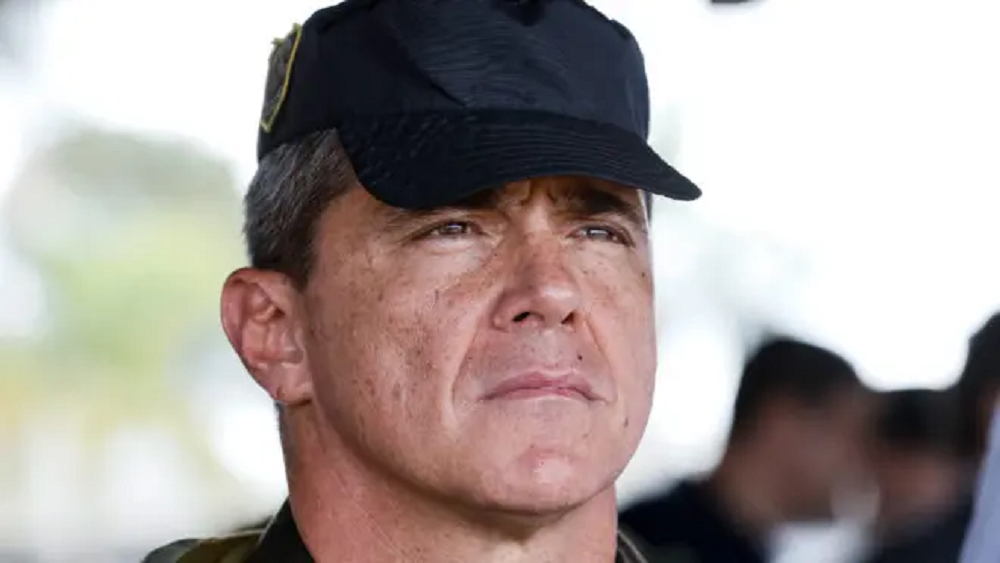 O general Mário Fernandes sério, em close, de boné preto, sem olhar para a câmera