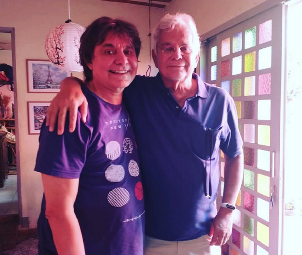 Lõ Borges e Yé Borges posando abraçados para foto, em pé