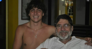 Francisco Frateschi e o pai, o ex-deputado estadual Paulo Frateschi (PT), abraçados, o primeiro sem camisa, ambos sorrindo para a câmera