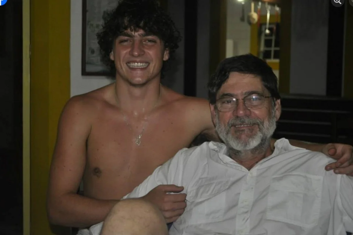 Francisco Frateschi e o pai, o ex-deputado estadual Paulo Frateschi (PT), abraçados, o primeiro sem camisa, ambos sorrindo para a câmera