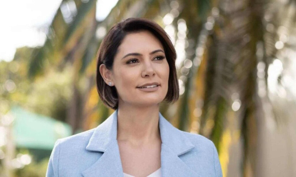 ex-primeira dama do Brasil, Michelle Bolsonaro, sorrindo, olhando para o lado, de roupa social azul