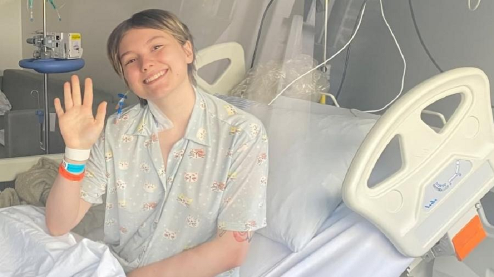 Isabel Veloso sorrindo, sentada em cama de hospital