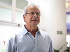 O ex-ministro José Dirceu de camisa social clara e óculos de grau, com expressão pensativa