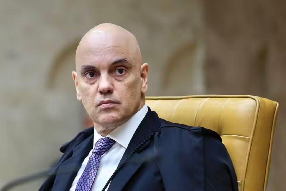 ministro Alexandre de Moraes sério, sentado, olhando para o lado sem olhar para a câmera