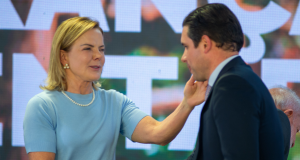 A ministra das Relações Institucionais, Gleisi Hoffmann, e o presidente da Câmara, Hugo Motta (Republicanos-PB), prestes a se abraçarem, e em aperto de mãos, em pé