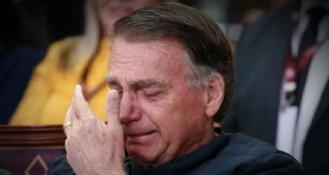Ex-presidente Jair Bolsonaro chorando com mão próxima ao rosto