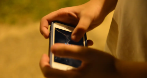 Mãos de criança mexendo em celular