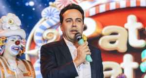 empresário Rinaldi Faria falando em microfone, sério