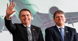 Jair Bolsonaro sorrindo e acenando e o governador de São Paulo, Tarcísio de Freitas (Republicanos), sorrindo de maneira tímida ao lado dele