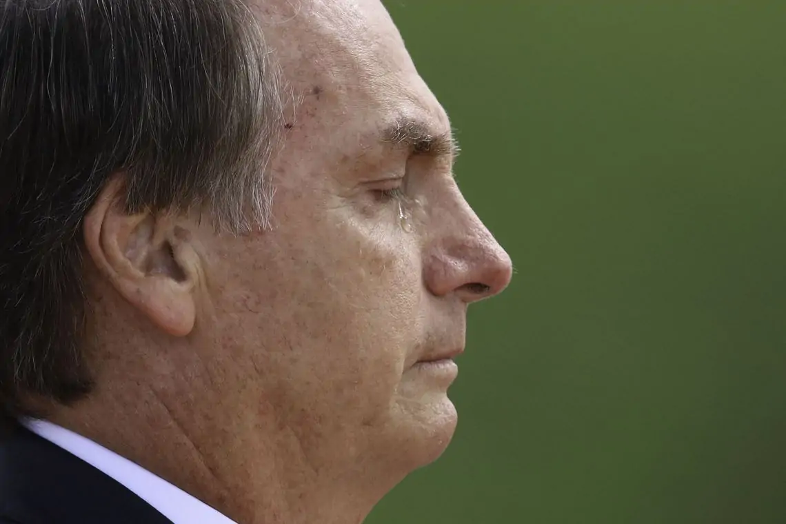 ex-presidente Jair Bolsonaro (PL) no canto esquerdo de foto, de perfil, chorando