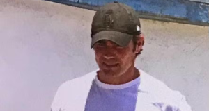 Vorcaro ao deixar a prisão, de cabeça baixa, de camiseta branca e boné verde, segurando Bíblia