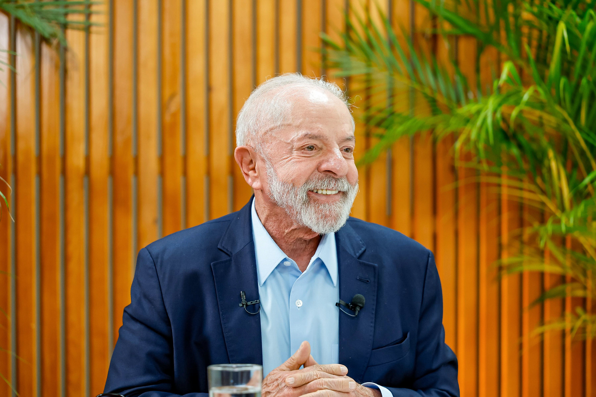 Lula olhando para o lado e sorrindo, sentado