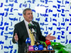 O deputado federal Lindbergh Farias (PT-RJ) em pé, perto de microfones, sério, gesticulando