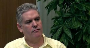 O ex-ministro da Economia de Cuba, Alejandro Gil, sério, de camisa amarela, olhando para o lado