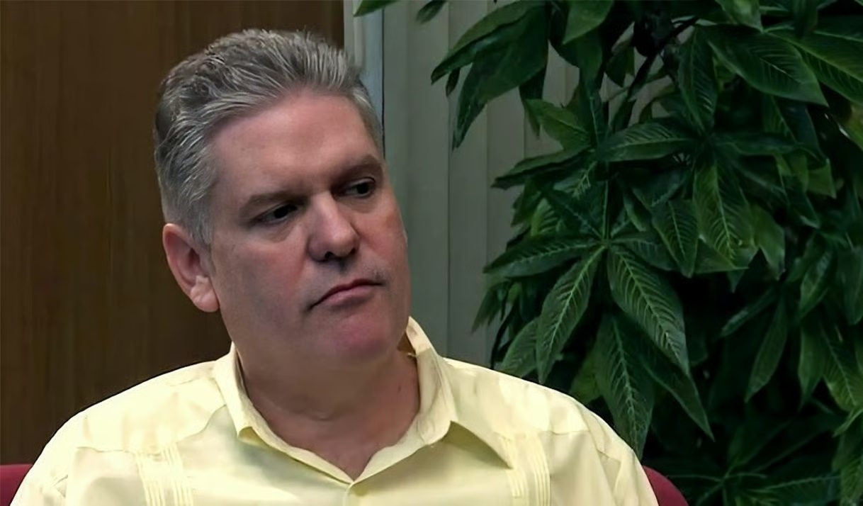 O ex-ministro da Economia de Cuba, Alejandro Gil, sério, de camisa amarela, olhando para o lado