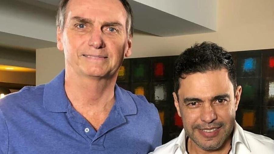 O ex-presidente Jair Bolsonaro (PL) e o cantor Zezé Di Camargo posando lado a lado para foto e sorrindo