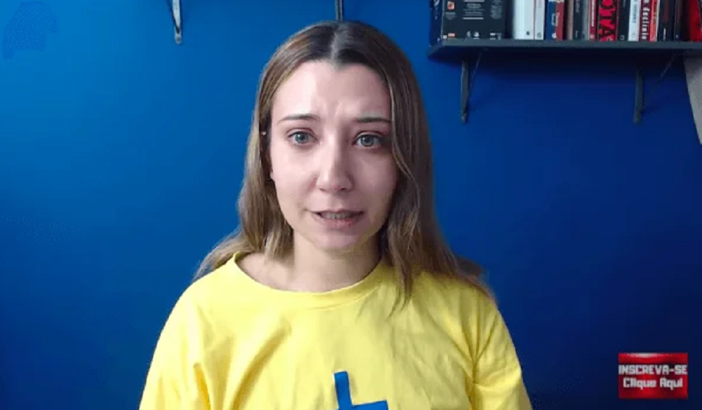 A influenciadora bolsonarista Camila Abdo de camiseta amarela e cabelo solto, falando para a câmera